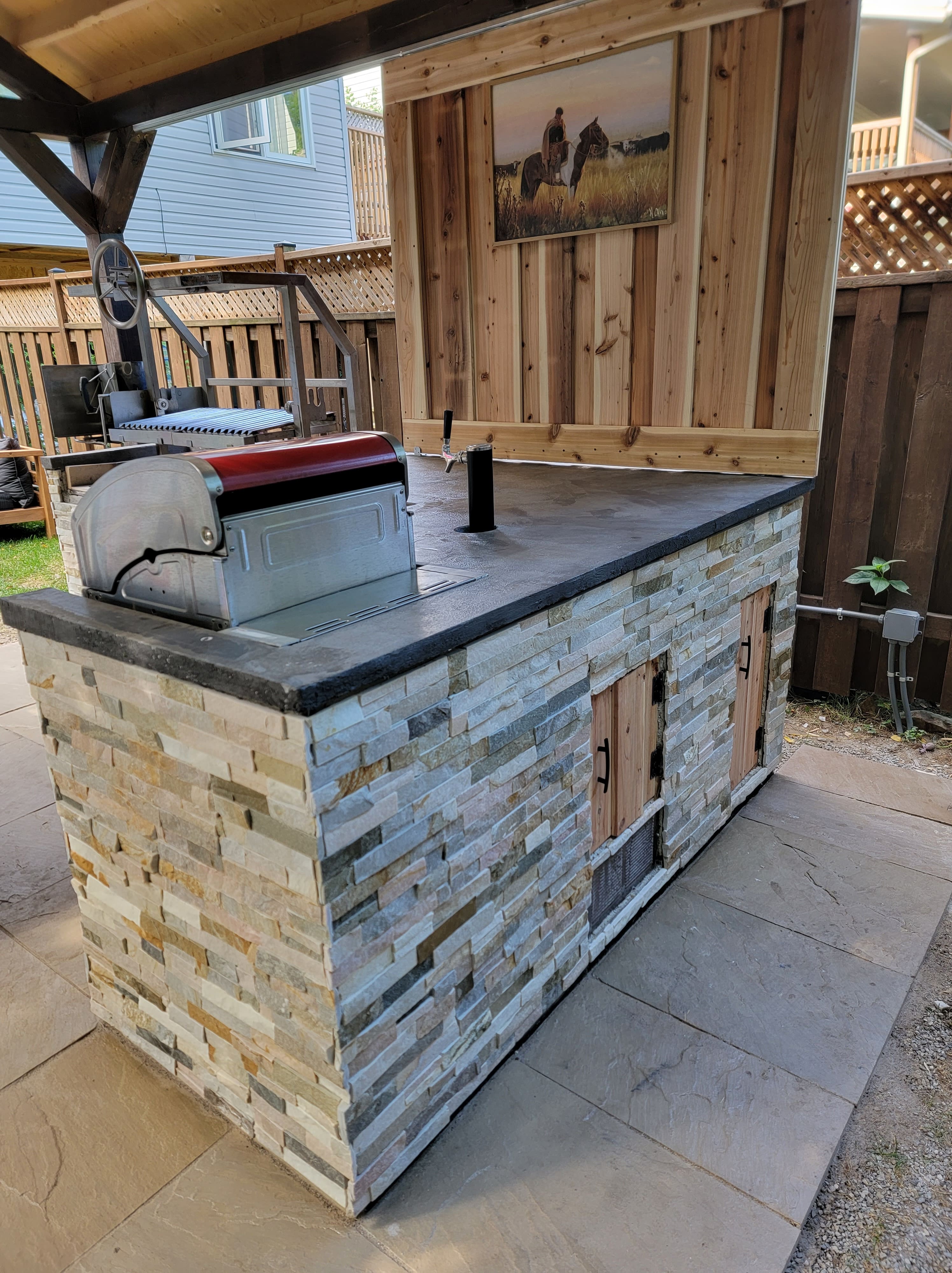Custom outdoor kitchen with modern appliances and stone countertop